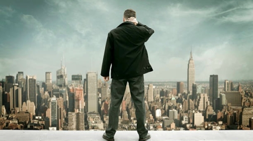 Man standing on the roof of skyscraper in New York city, photomontage.